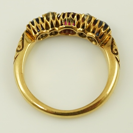 An early 20th century gold, ruby, sapphire and diamond cluster set half hoop ring